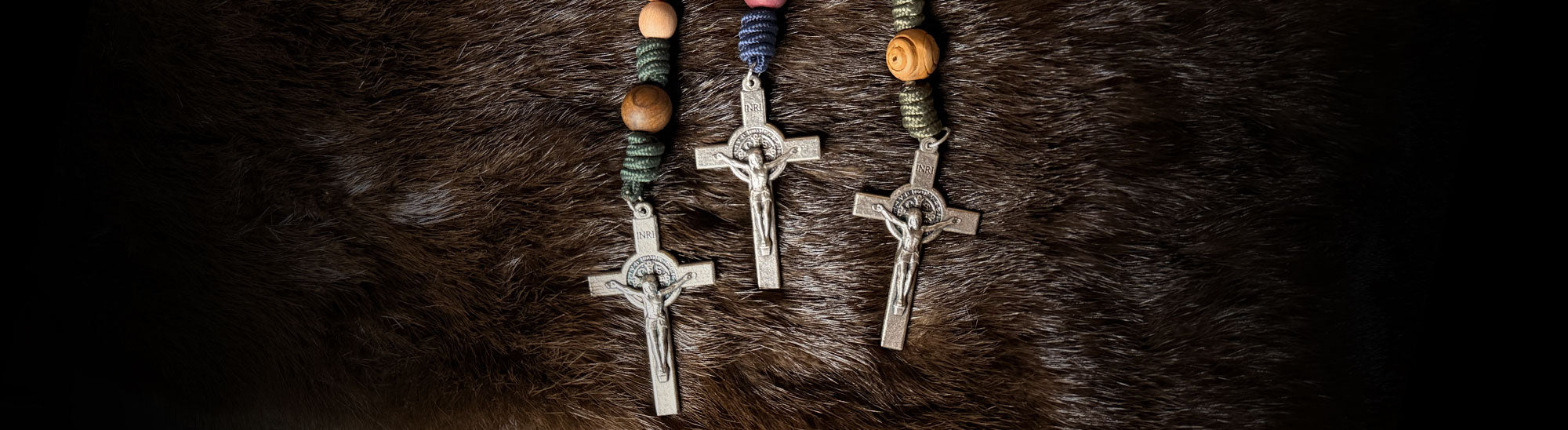 Three silver crosses on a dark textured surface