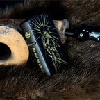 Black zippo with engraved design and text on a fur surface