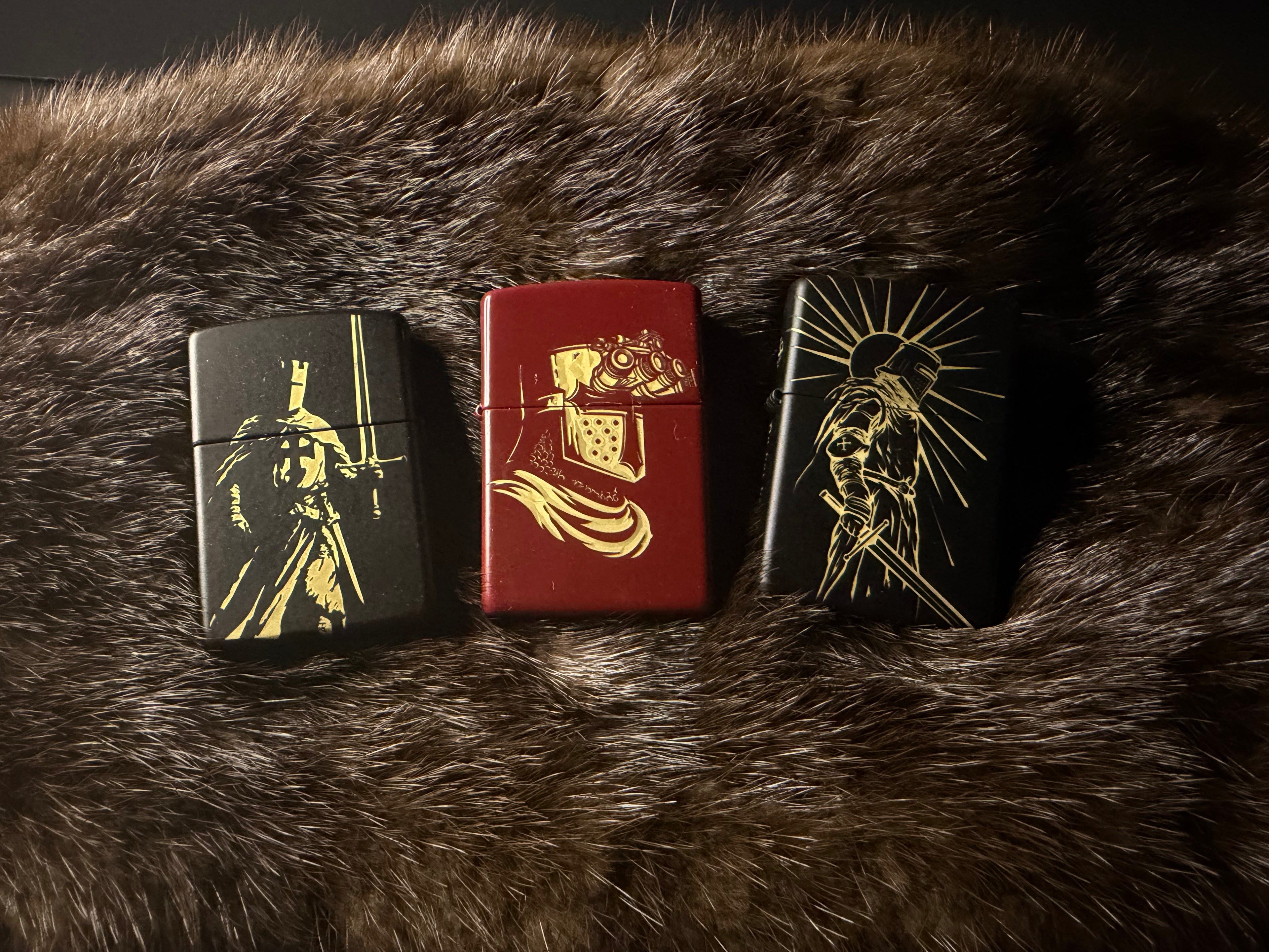 Three decorative laser engraved crusader zippos with gold designs on a dark fur background