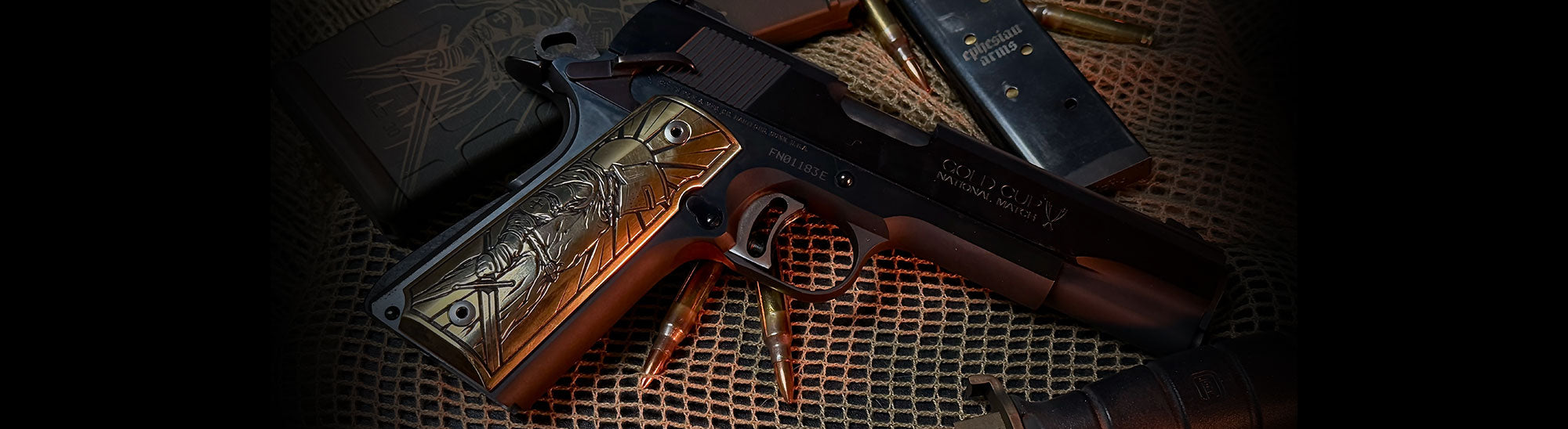 Custom 1911 with laser engraved brass grip, glock knife, and ammunition on a textured surface